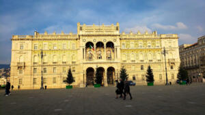 Glass mosaics on Government Palace glowing in sunset in Unity Square, Trieste.