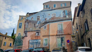 Murals painted over old buildings in Agde.  Which windows are real?