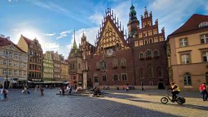 Mike biking past the Town Hall in Market Square, Wrocław, Poland
