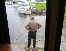 Sokn camping, Mike feeding swans beside RV  